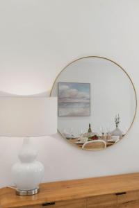 a mirror on a wall with a table in a room at Ocean Vista Escape - A Lofty Beachfront Penthouse in Wollongong