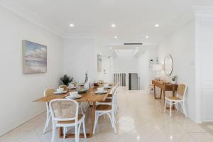 a dining room with a wooden table and chairs at Ocean Vista Escape - A Lofty Beachfront Penthouse in Wollongong +37 photos