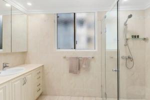 a bathroom with a shower and a sink at Ocean Vista Escape - A Lofty Beachfront Penthouse in Wollongong
