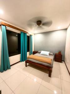 1 dormitorio con cama y ventana grande en Apu House, Privacidad y paz para disfrutar en pareja, familia o amigos, con aire acondicionado, en Turrúcares