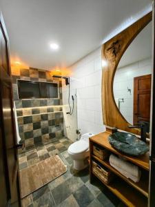 y baño con aseo, lavabo y espejo. en Apu House, Privacidad y paz para disfrutar en pareja, familia o amigos, con aire acondicionado, en Turrúcares
