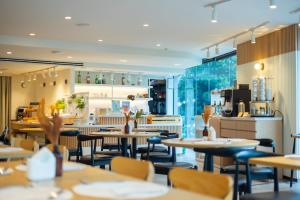 un ristorante con tavoli e sedie e una cucina di Aster Hotel and Residence by At Mind a Centro di Pattaya Altre 100 foto