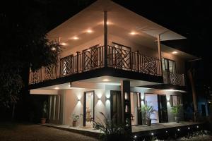 una casa con un balcón encima por la noche en Apu House, Privacidad y paz para disfrutar en pareja, familia o amigos, con aire acondicionado, en Turrúcares