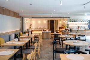 un restaurante con mesas, sillas y una barra en Aster Hotel and Residence by At Mind en Pattaya centro