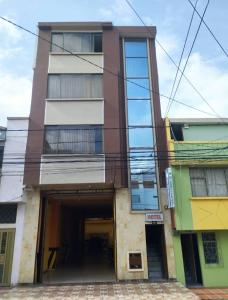 un edificio alto con un garaje delante en Hotel Torre Bolívar, en Pasto