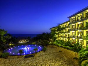 ein Hotel mit einem großen Pool vor einem Gebäude in der Unterkunft Lotus Muine Resort & Spa in Mui Ne