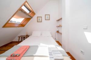una camera da letto con un letto bianco e una finestra di Casa Amarela, 9-room beach house a Praia da Barra