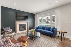 sala de estar con sofá azul y chimenea en Includes AC Private Office Garage Parking and Easy Access to the Anthony Henday, en Nisku