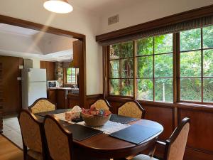 a dining room with a table and chairs and a kitchen at Arnica Views Summit Retreat in Mount Dandenong