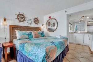 a bedroom with a large bed and a kitchen at The Sea & Breeze:1 Bed Condo w/Pool Steps to Beach in Tybee Island +12 photos