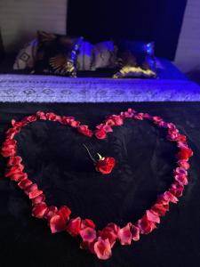 um coração feito de rosas vermelhas sobre uma mesa em ô Bois Dormant, Bungalow & jacuzzi privé em Saint-André