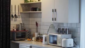 a kitchen with a counter with a microwave and a microwave at West Melton Bed and Breakfast in West Melton