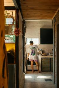 um homem parado na cozinha de uma pequena casa em ESPACIO MINGA, casa quinta en la ciudad, hasta 8 personas em Corrientes