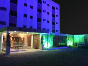 een groot gebouw met paarse verlichting op een parkeerplaats bij Palace Hotel Campos dos Goytacazes in Campos dos Goytacazes