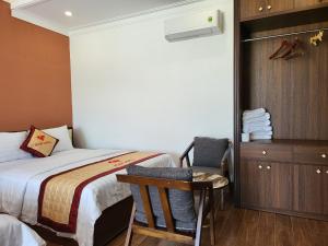 a bedroom with a bed and a chair and a dresser at RUBY HOTEL Vĩnh Long in Vĩnh Long