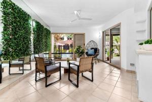a living room with a table and chairs at Reef Apartment Cairns in Edge Hill