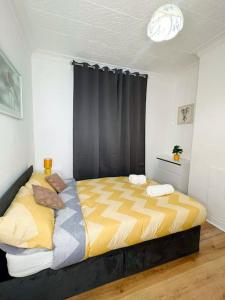 um quarto com uma cama grande com lençóis amarelos e cinzentos em Cozy 3BR Urban Oasis in the City Hub em Manchester