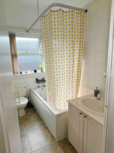 uma casa de banho com um WC e uma cortina de chuveiro em Cozy 3BR Urban Oasis in the City Hub em Manchester