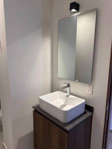 y baño con lavabo blanco y espejo. en CD401 Increíble Loft la mejor zona de la ciudad, en Guadalajara