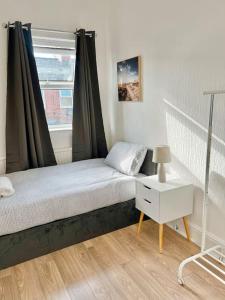 um pequeno quarto com uma cama e uma janela em Cozy 3BR Urban Oasis in the City Hub em Manchester