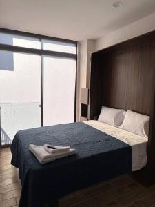 1 dormitorio con 1 cama grande con manta azul en CD401 Increíble Loft la mejor zona de la ciudad, en Guadalajara