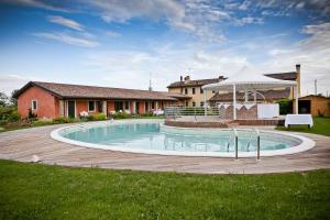 a large swimming pool in the yard of a house at Agriturismo Ai Casoni in Codognè