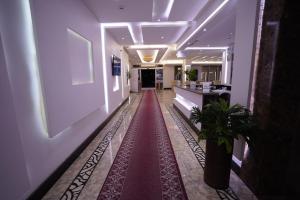 un pasillo con una alfombra roja en un edificio en Hotel and Apartments Al Raqi Mall Artiaad, en Tabuk