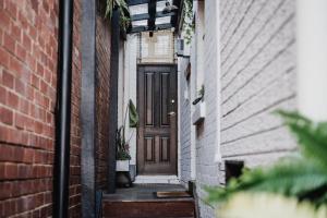 een steegje met een bruine deur en een bakstenen gebouw bij Your home on Smith St Collingwood (With Parking) in Melbourne