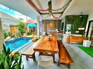 a dining room with a wooden table and a swimming pool at Arawan Pool Villa Hua Hin in Hua Hin