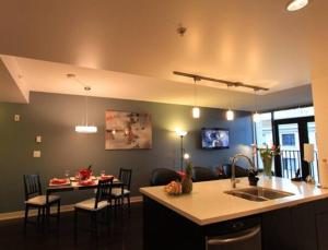eine Küche und ein Wohnzimmer mit einem Tisch und einer Theke in der Unterkunft The Hollywood North Suite in Victoria
