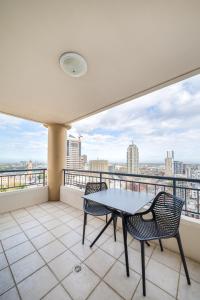 einen Balkon mit einem Tisch und Stühlen sowie Aussicht in der Unterkunft Oaks Sydney Castlereagh Suites in Sydney