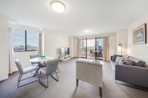 悉尼Oaks Sydney Castlereagh Suites的带沙发和桌子的客厅