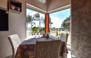 a dining room with a table and chairs and a large window at 2 Bedroom Beautiful Home In Acireale in Acireale