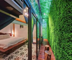 een slaapkamer met een groene muur en een bed bij Victory Hotel in Hue