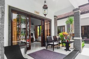 Balam Bali Villa في Mengwi: فناء مع كراسي وطاولة في المنزل