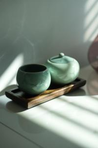 two green bowls sitting on a wooden tray at Stay Vibe Healing House in Seoul