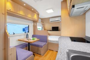 einen kleinen Wohnwagen mit einem Bett und einem Tisch in der Unterkunft Poseidon Caravan in Gapyeong