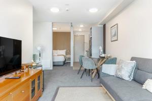 a living room with a couch and a table at Zodiak Stays Cozy CBD 2BR Near Top Dining Spots in Auckland