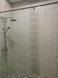 y baño con ducha y puerta de cristal. en Homestay Mutiara en Yogyakarta