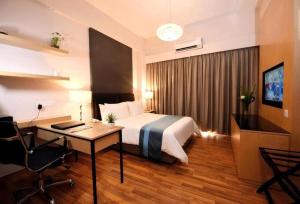 um quarto de hotel com uma cama e uma secretária em Imperial Heritage Hotel Melaka I City Centre I Free Himalayan Salt Room Access I Free Wifi I Free Parking em Malaca