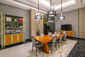 Un comedor con mesa y sillas de madera. en StöckHölmm at Anderson apartment, en Surabaya