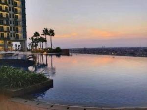 una gran masa de agua con palmeras y un edificio en StöckHölmm at Anderson apartment, en Surabaya