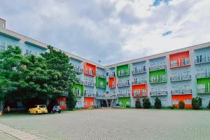 duży apartamentowiec z kolorowymi oknami i żółtym samochodem w obiekcie Gading Serpong Hotel Near Stadion Persita Redpartner w mieście Anggris