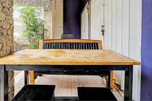 a wooden table in a room with a bench at OYO 93328 Graha Citra Syariah in Karajaan