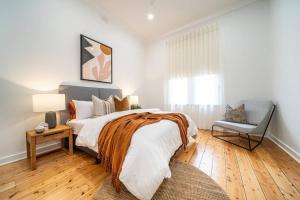 1 dormitorio con 1 cama grande y 1 silla en Ambrosia - Designer 3BR WiFi en Kensington and Norwood