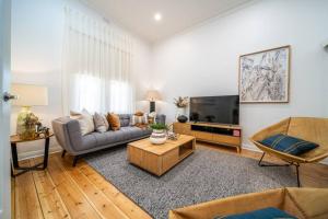 sala de estar con sofá y TV en Ambrosia - Designer 3BR WiFi en Kensington and Norwood