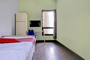 a small room with a bed and a window at OYO 93328 Graha Citra Syariah in Karajaan