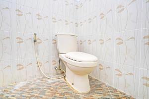 a bathroom with a toilet with a hose at OYO 93328 Graha Citra Syariah in Karajaan