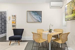 uma sala de jantar com mesa e cadeiras em Comfy 2-Bed Apartment with AC throughout em Sydney