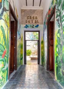 a hallway with colorful paintings on the walls of a building at Casa Iktal Luxury - Centro Mérida in Mérida +27 photos